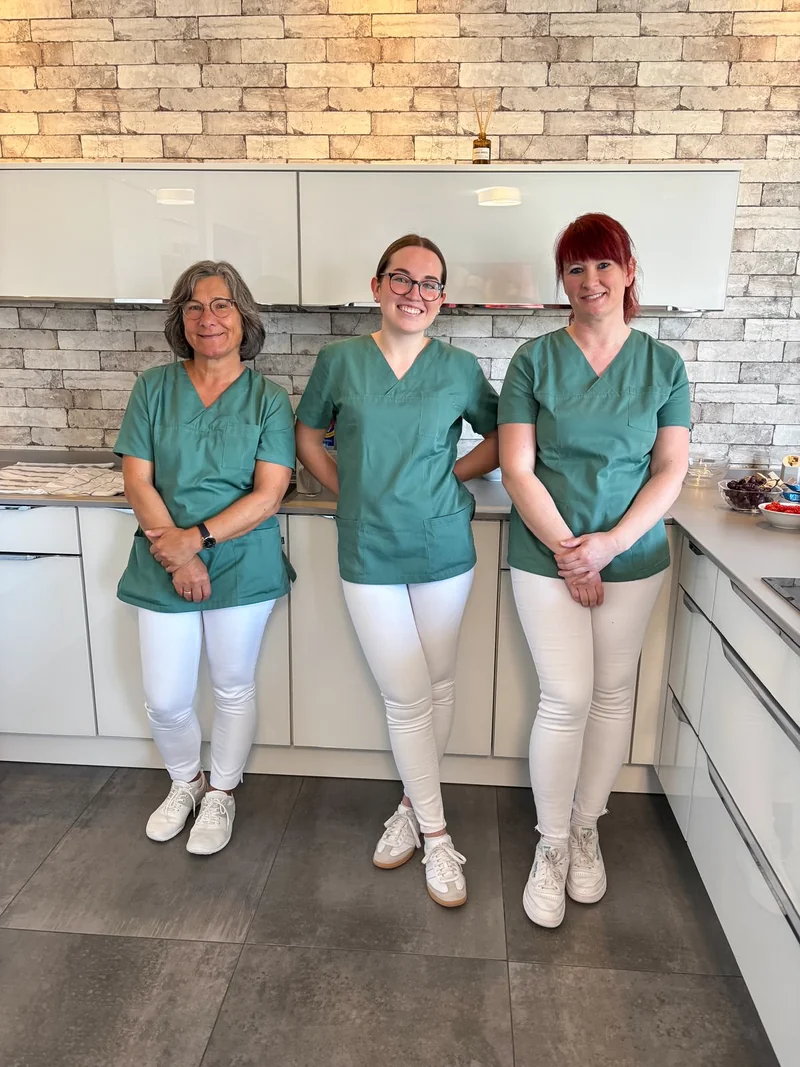 Drei Personen in Praxisbekleidung vor der offenen Küche der neuen Dental Lounge